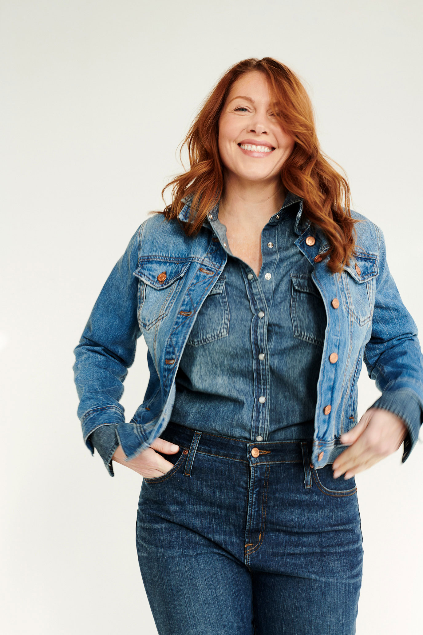 Red-haired female model styled in denim outfit