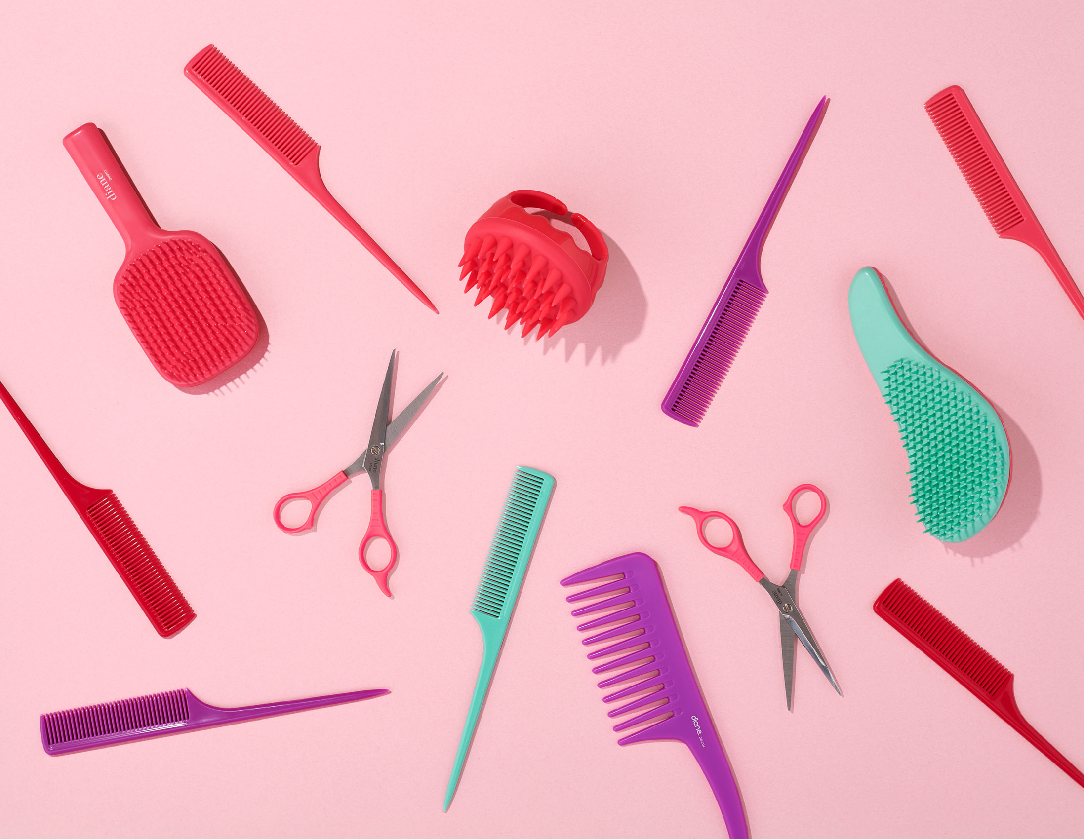 Variety of hair tools on pink surface