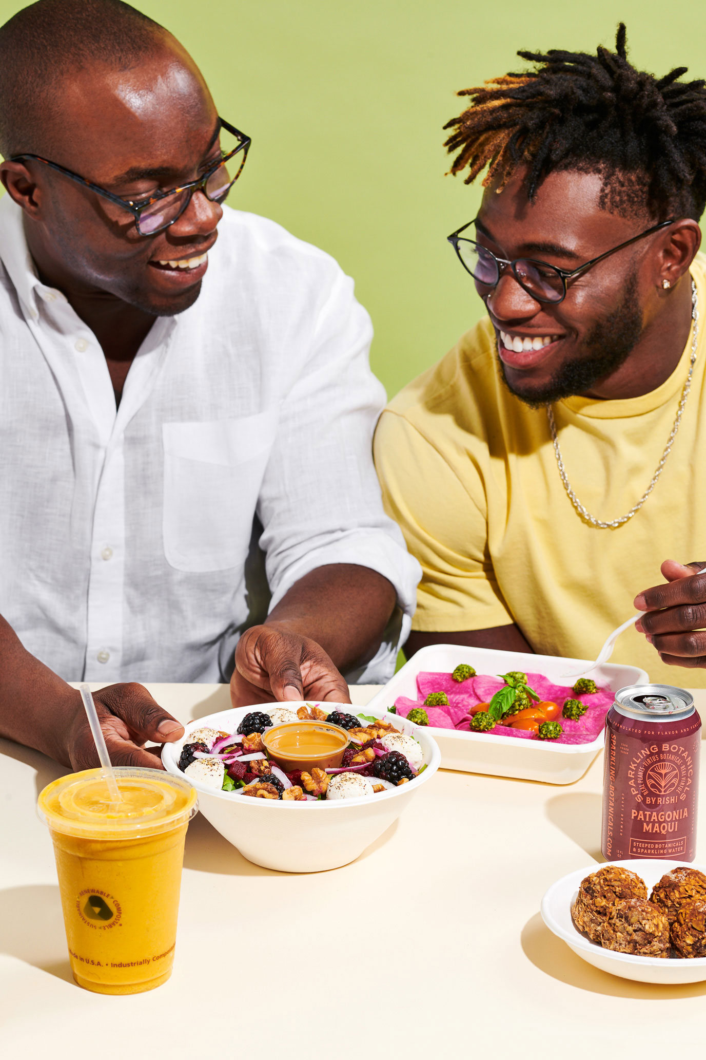 Two men with a selection of plant-based meals, snacks and beverages