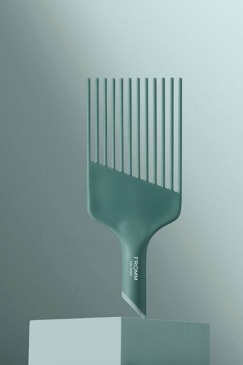 Mint green pick comb suspended on pedestal