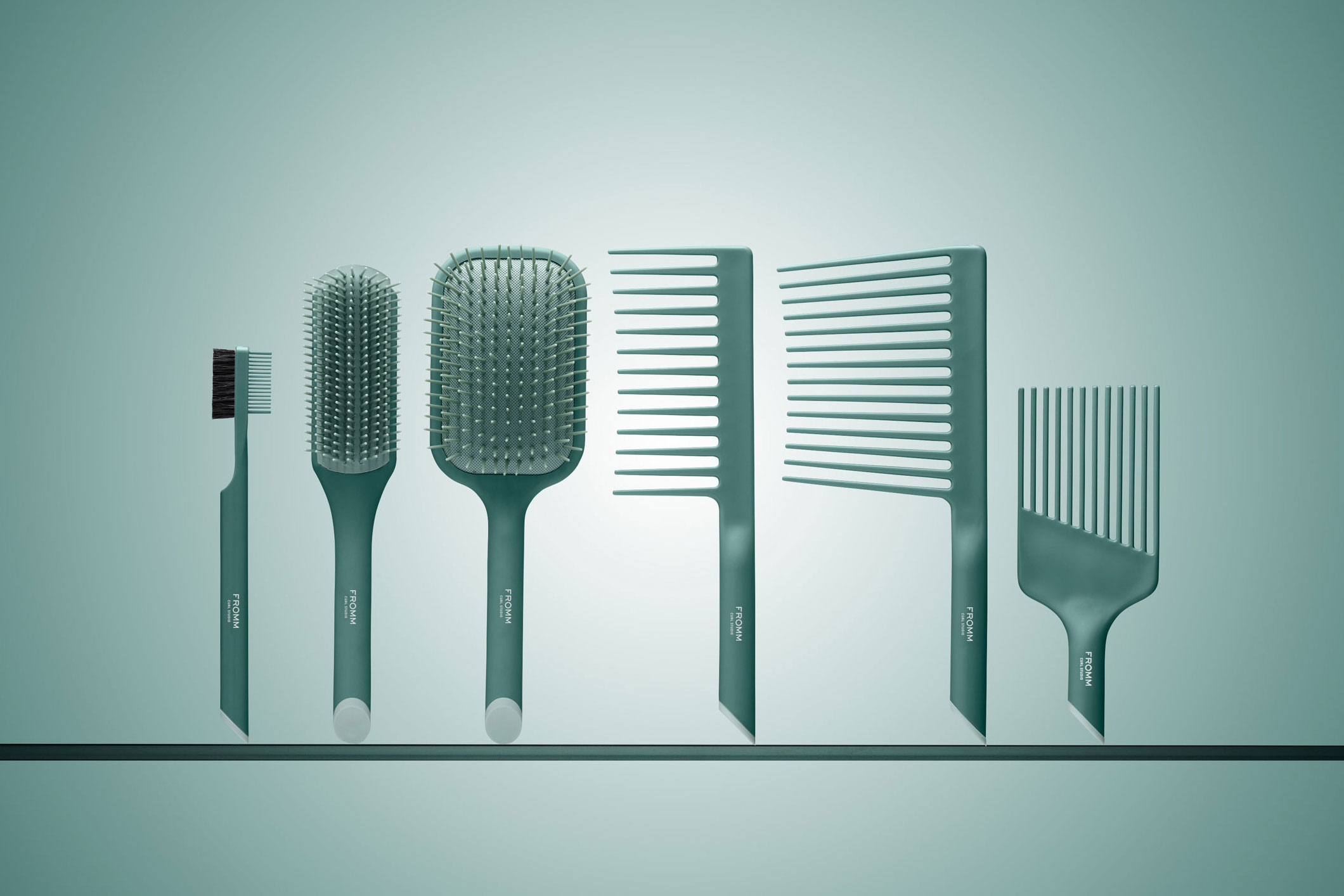 Collection of mint green brushes and combs with suspended effect on flat platform