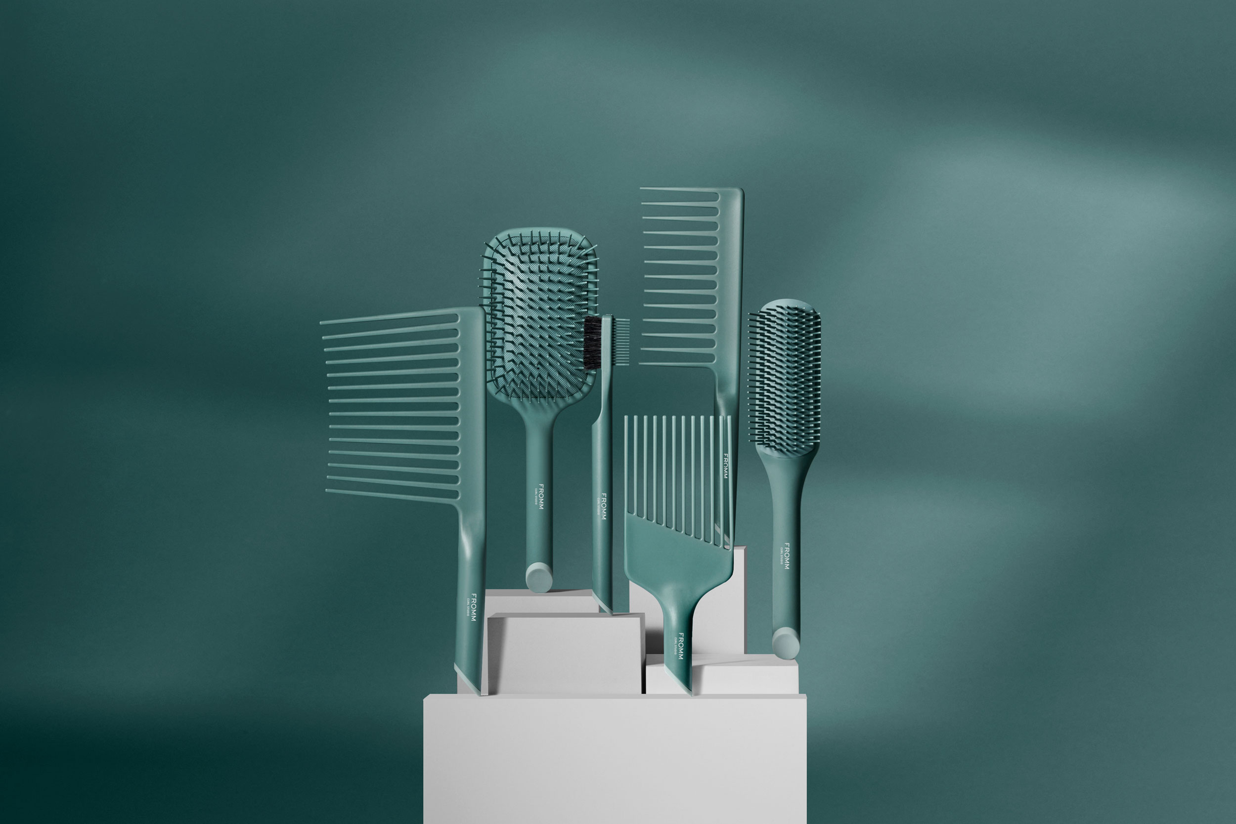 Collection of green brushes and combs suspended vertically on pedestals