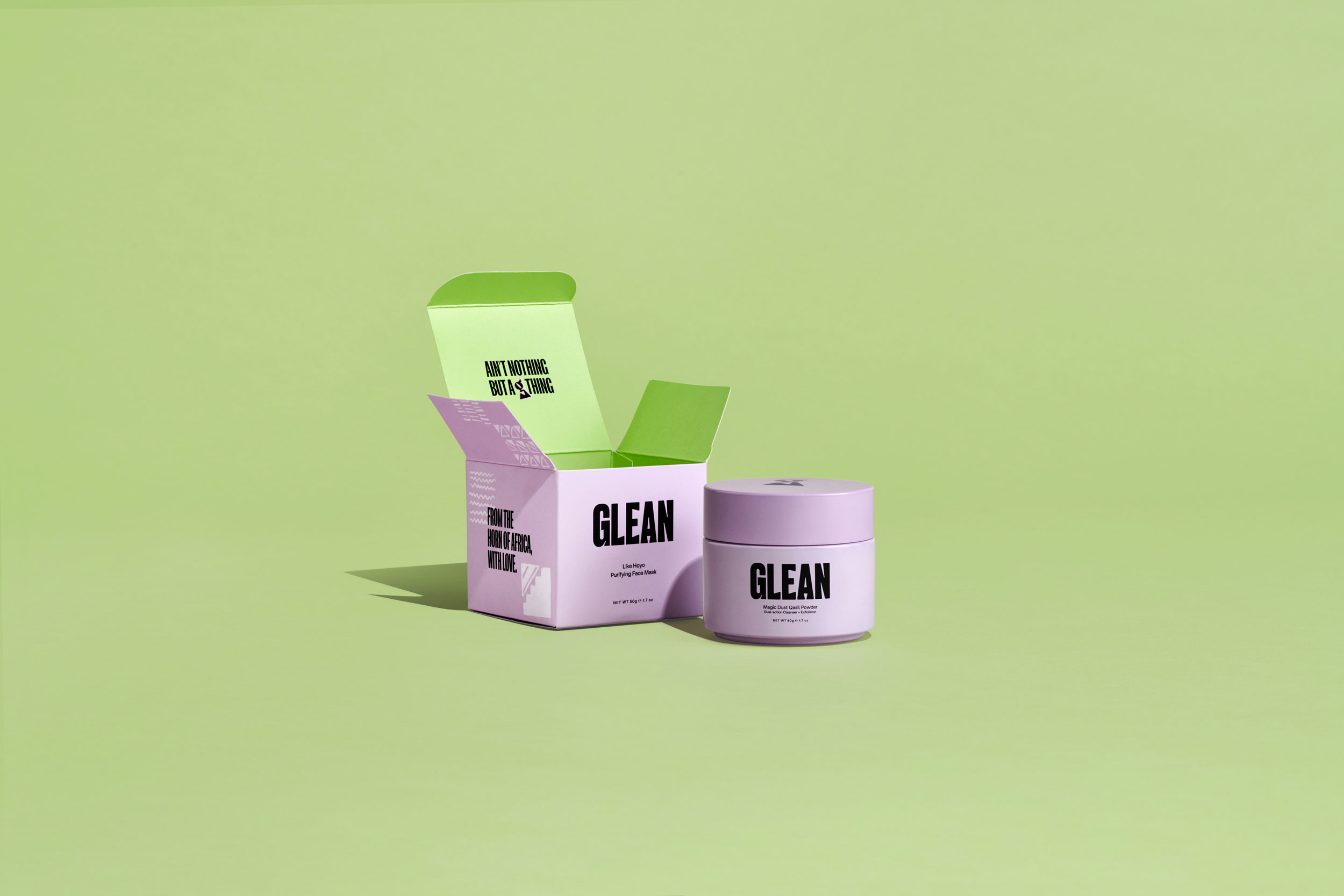 Skincare product with purple packaging and green interior on green sweep