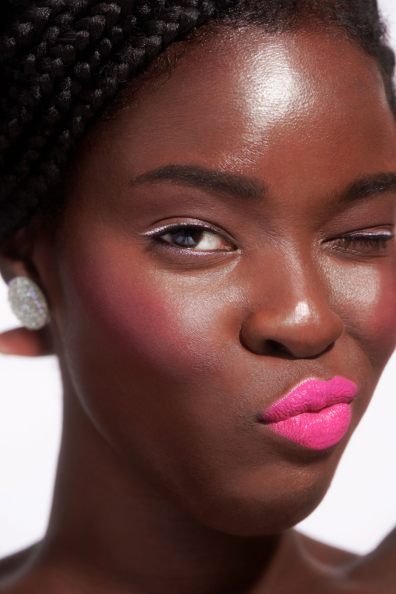 Tight portrait of Black female model with white eyeliner and bright pink lipstick