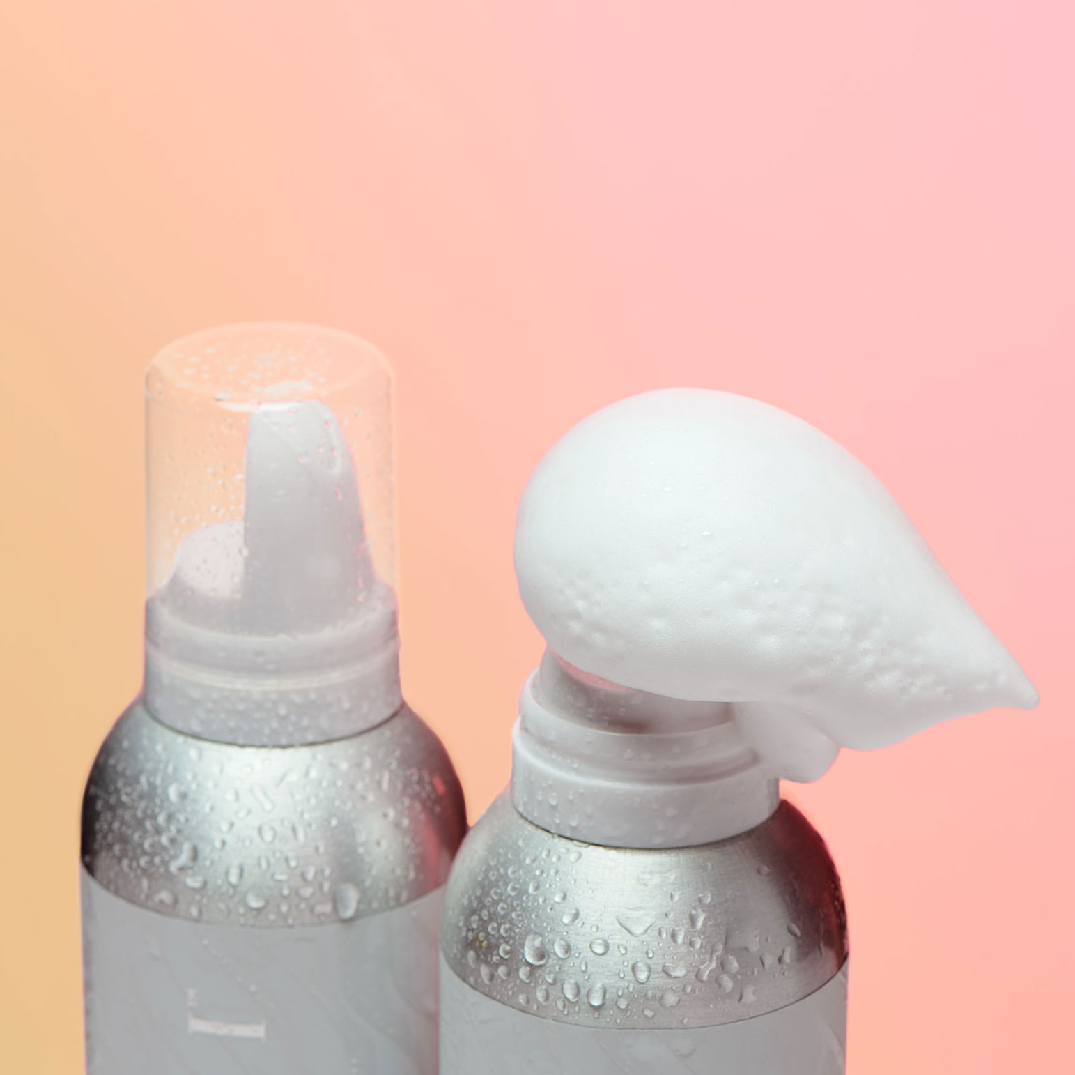 Two volumizing mousse products including one with mousse coming out of its container