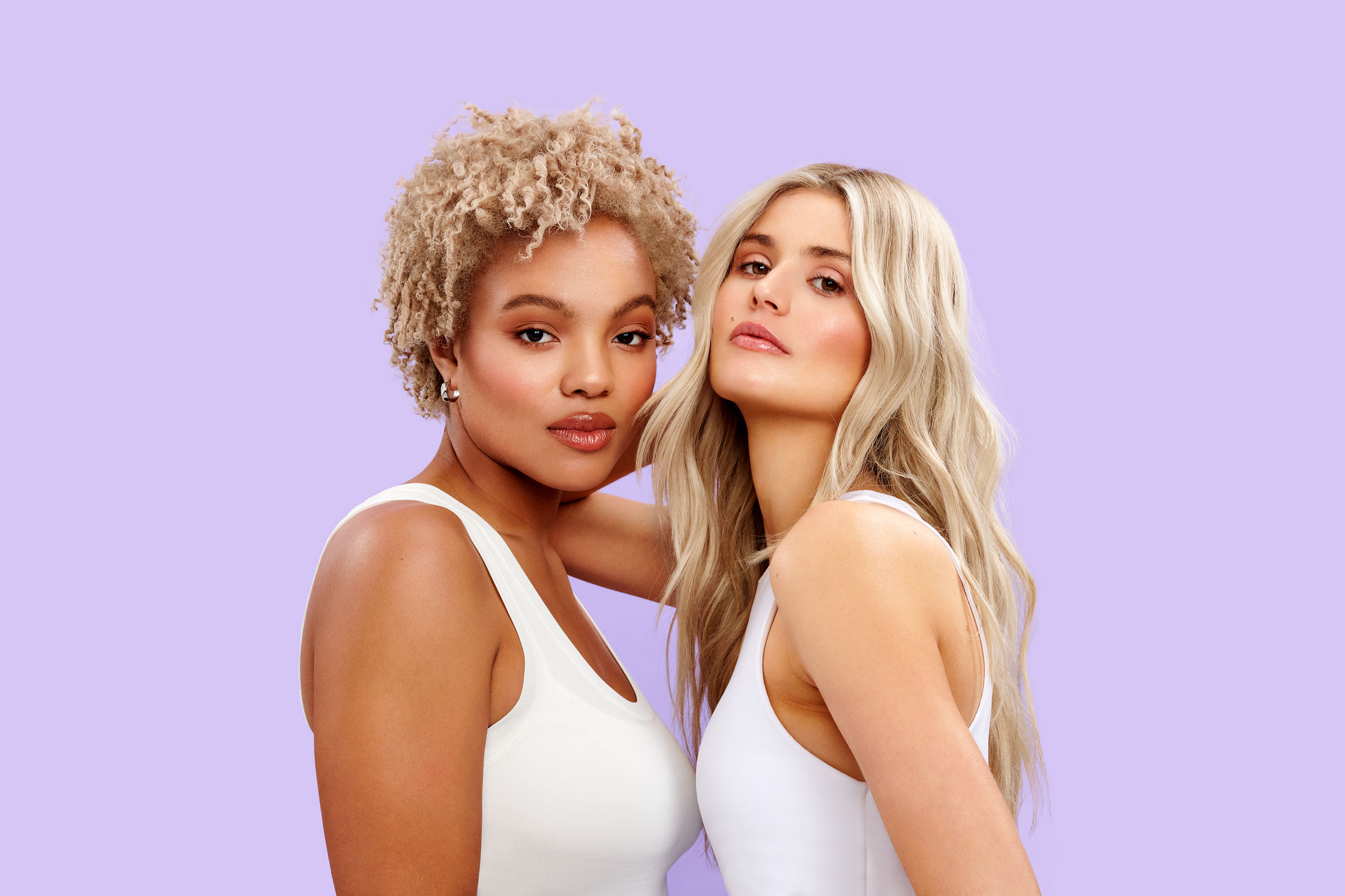 Two women showcasing blonde haircare product treatment