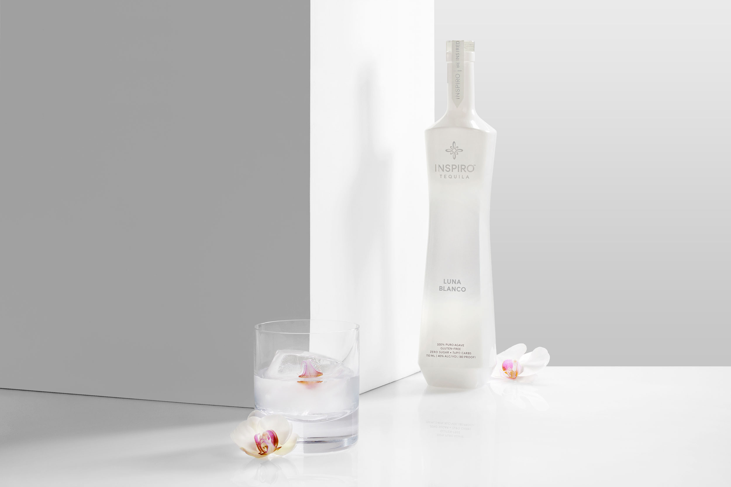 Bottle of tequila with cocktail and flowers