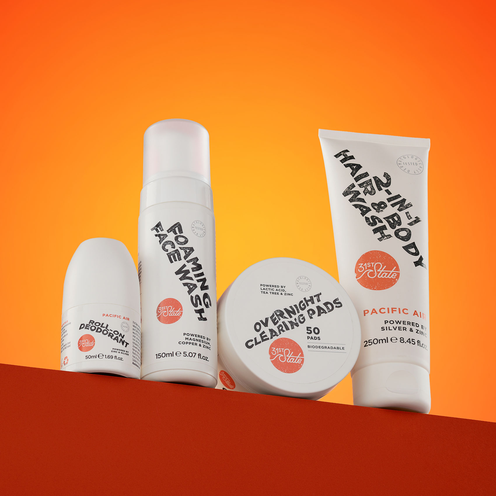 Set of four skin care products balanced on ledge of orange set