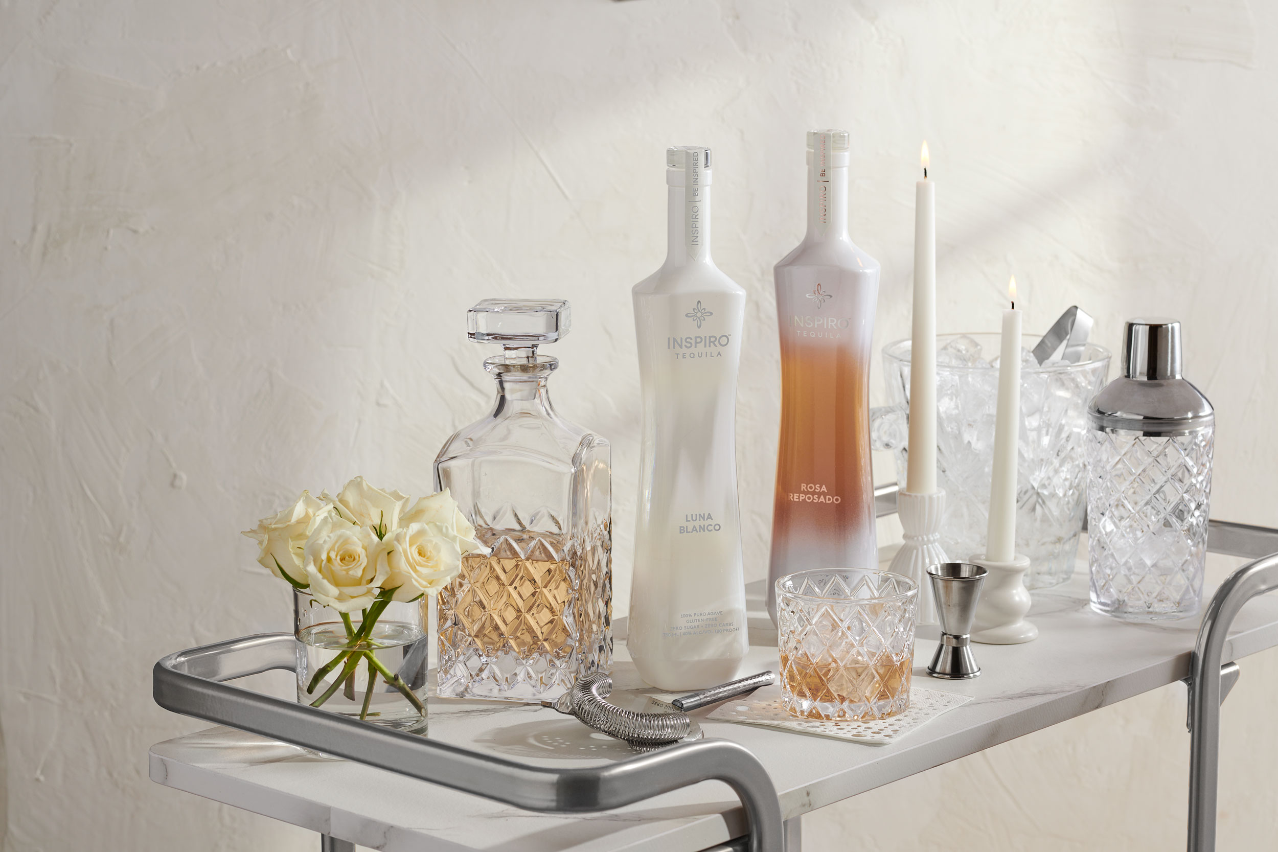 Styled bar cart with bottles of tequila and beverage accessories