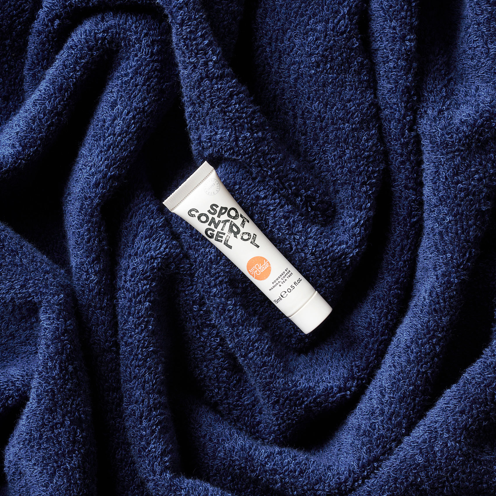 Skin care product nestled in blue towel