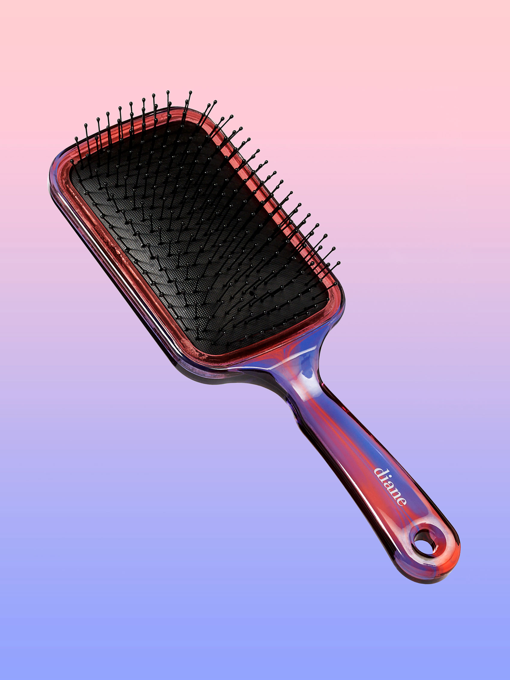 Square paddle brush suspended in air on pink and purple gradient