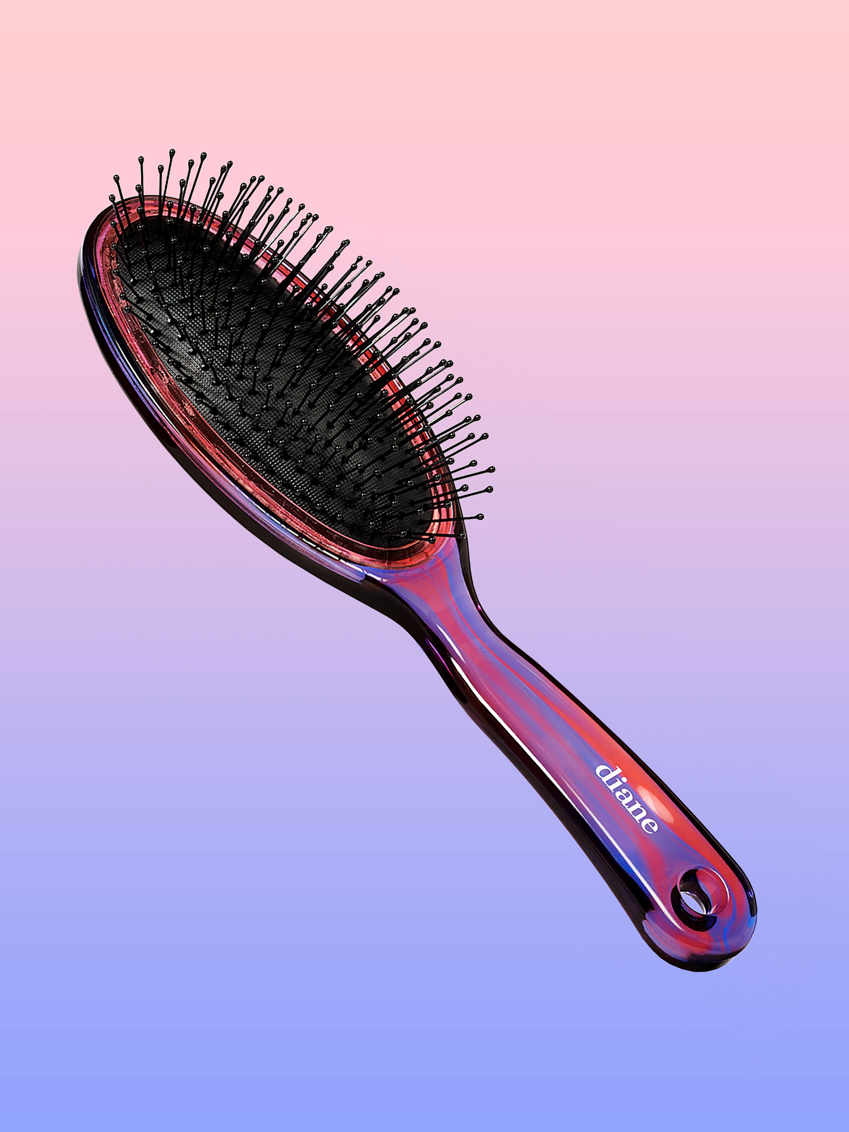 Oval paddle brush suspended in air on pink and purple gradient